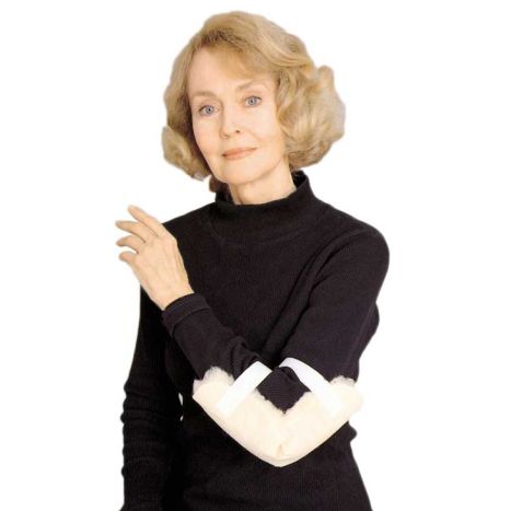Woman wearing a black sweater with a white cast on her arm against a white background