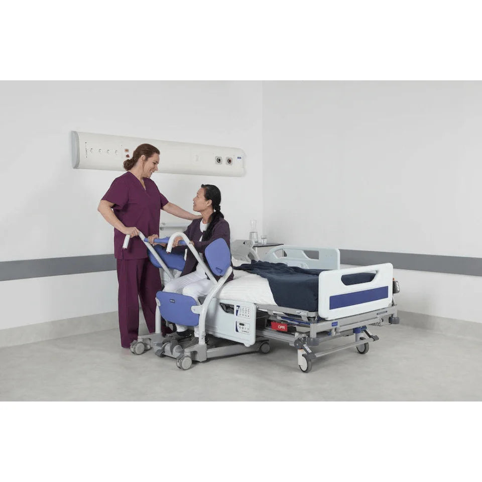 Person using a hospital bed with a nurse assisting in a clinical setting