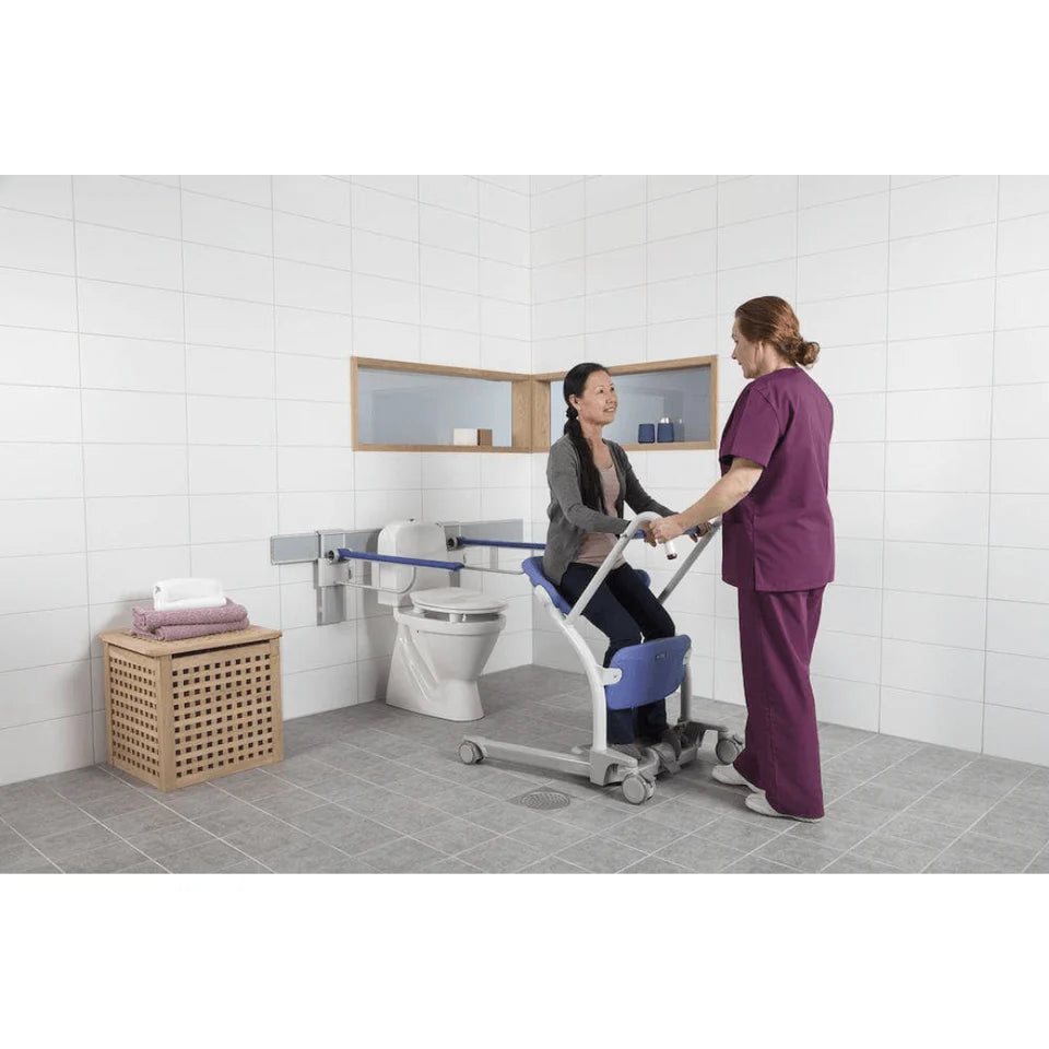 Person using a wheelchair being assisted by another person in a bathroom setting.