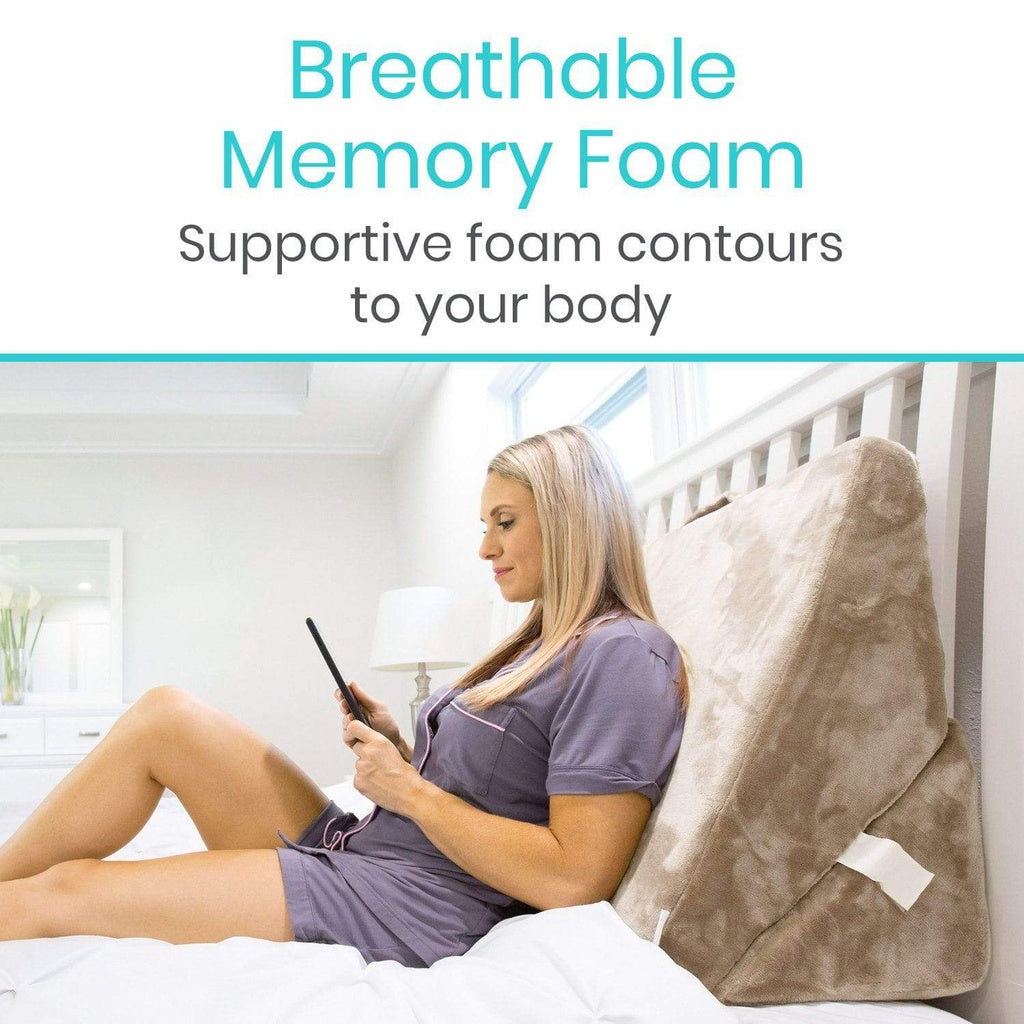 Woman using a smartphone with a beige wedge pillow on a bed, text 'Breathable Memory Foam' and 'Supportive foam contours to your body'.
