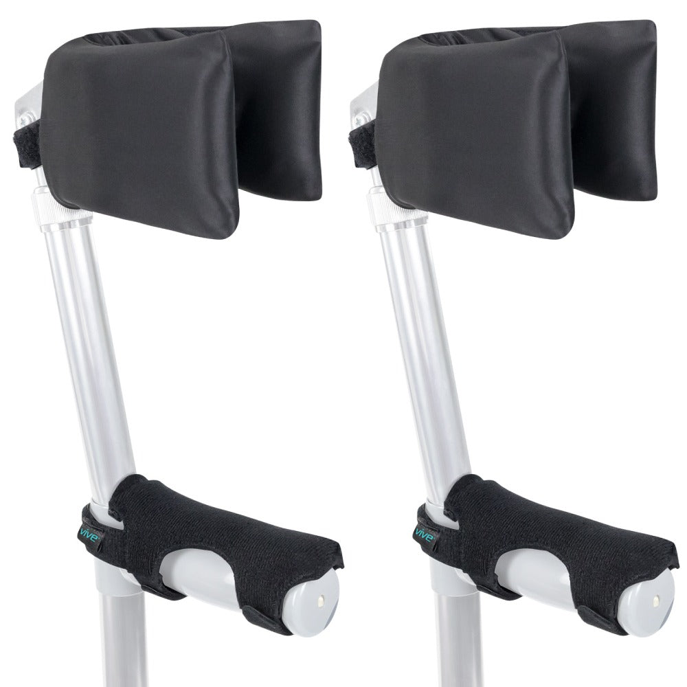 Pair of crutches with black arm pads and foot covers on a white background
