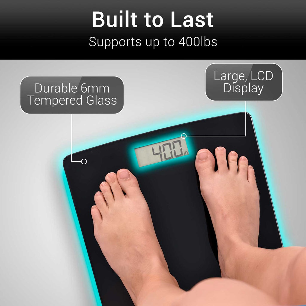 Digital bathroom scale with feet on it, displaying weight, on a gray background.