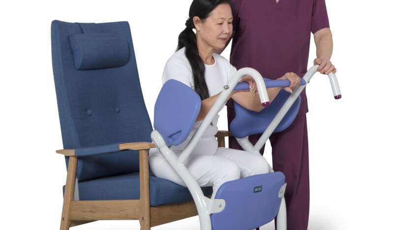 Person using a blue transfer chair with a caregiver assisting them.
