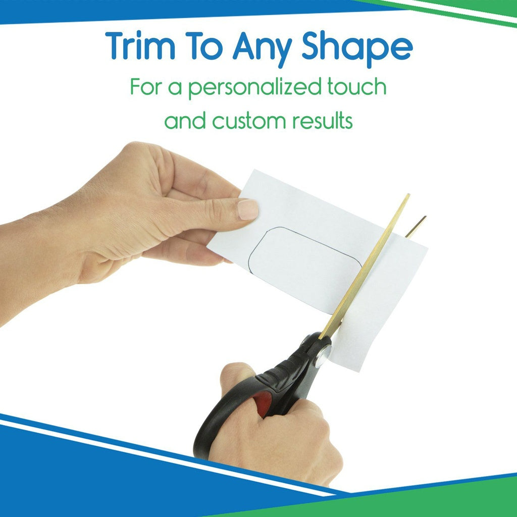 Person using scissors to trim a piece of paper with a cut-out shape, on a white background with blue and green accents.