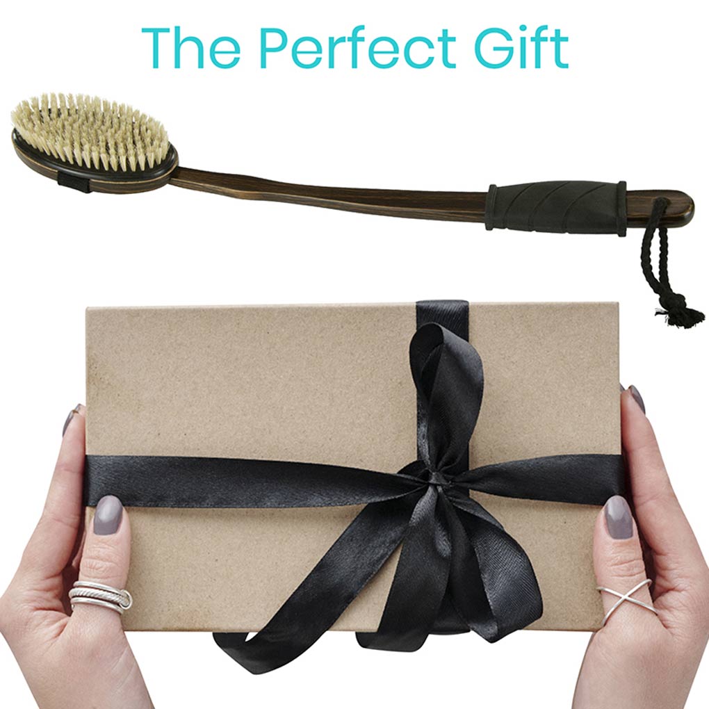 Gift box with black ribbon held by hands, with a grill brush above on a white background.