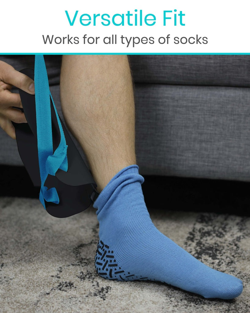 Person wearing blue socks with a black pattern, sitting on a gray couch.