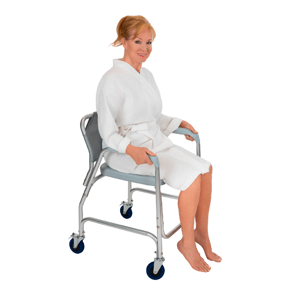 Woman in a white robe sitting on a gray shower chair with wheels on a black background