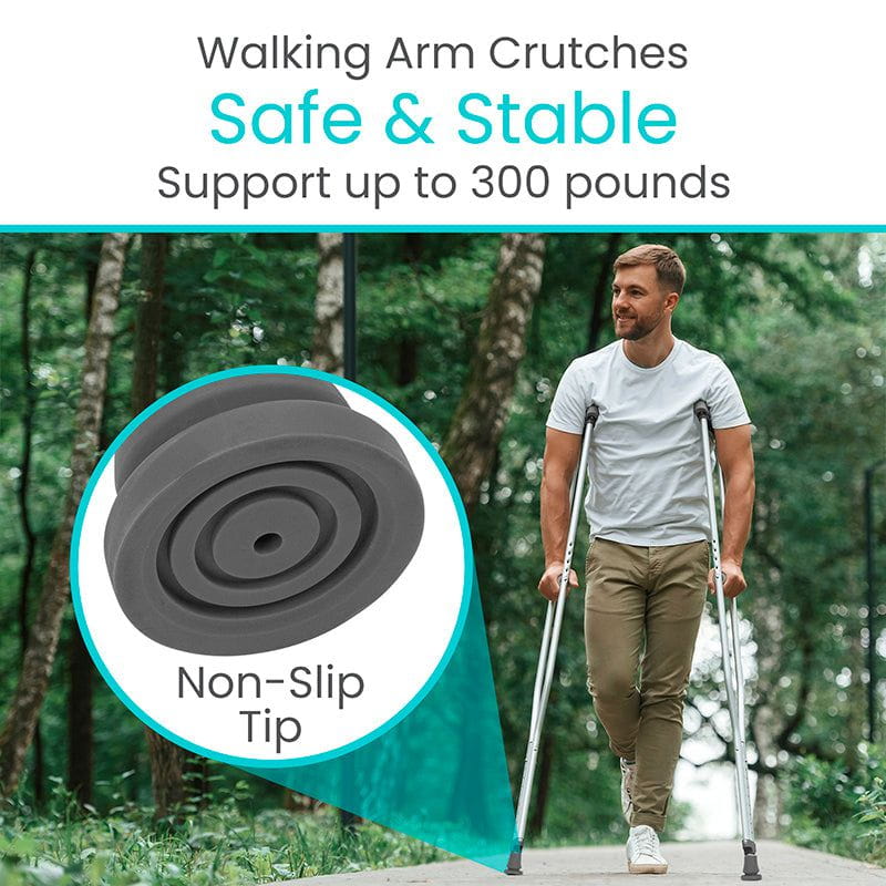 Man using walking arm crutches with a focus on non-slip tips in a forest setting.