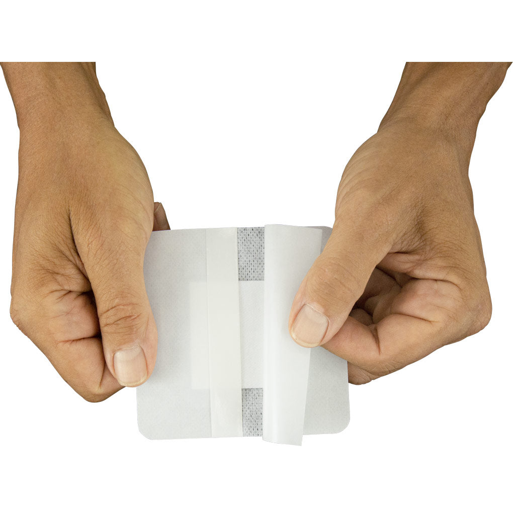 Hands holding a roll of white tape against a white background