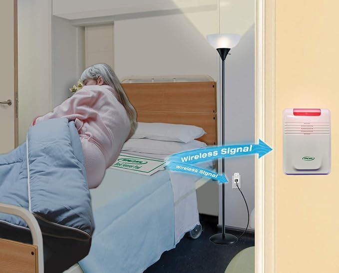 Woman in bed with a medical alert system device on the wall next to her.