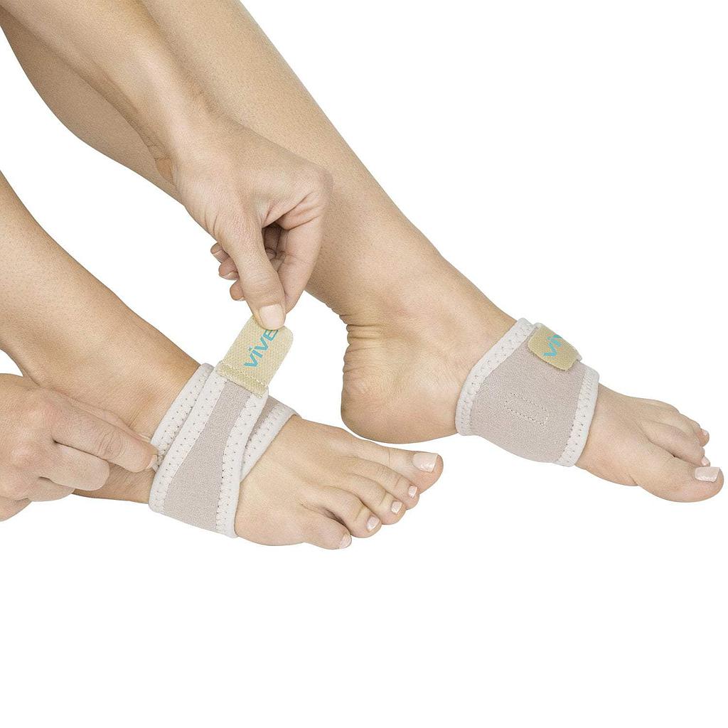 Person wearing beige toe separators on feet with a white background