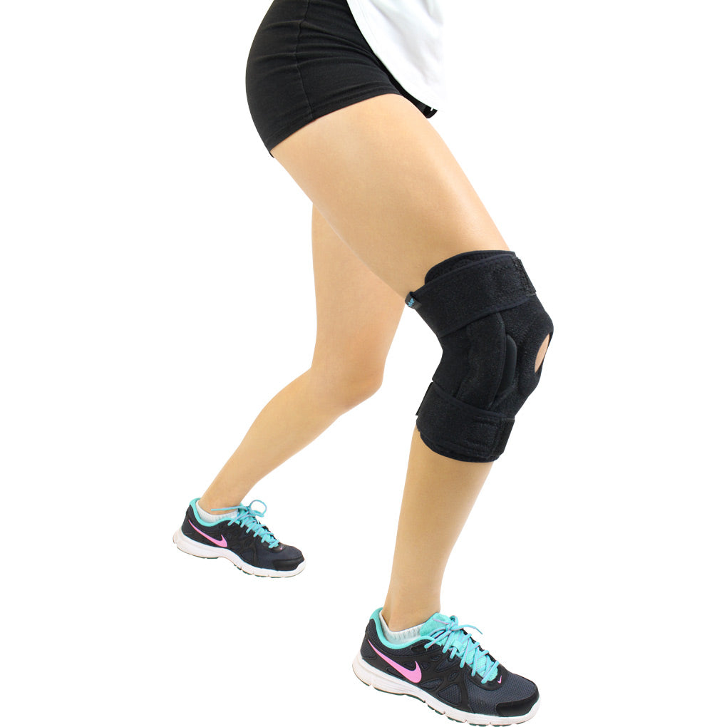 Person wearing a black knee brace on a white background
