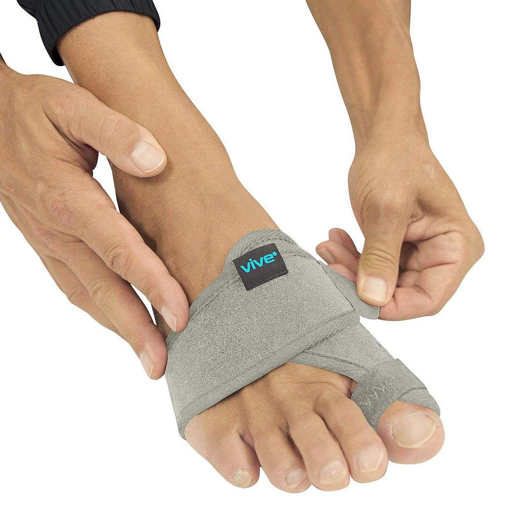 Person wearing a gray Vive bunion corrector on their foot against a white background