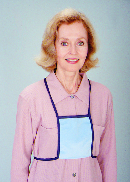 Woman wearing a pink coat with a blue pocket on a plain background