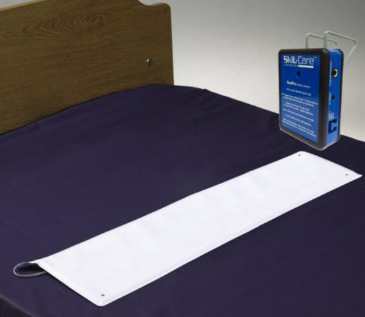 Bed with a white sensor pad and blue device on a gray background
