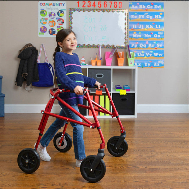 Child using a red walker in a classroom setting