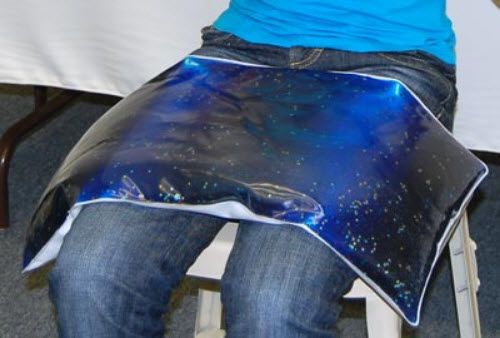 Person wearing a blue apron with a starry night design over jeans.