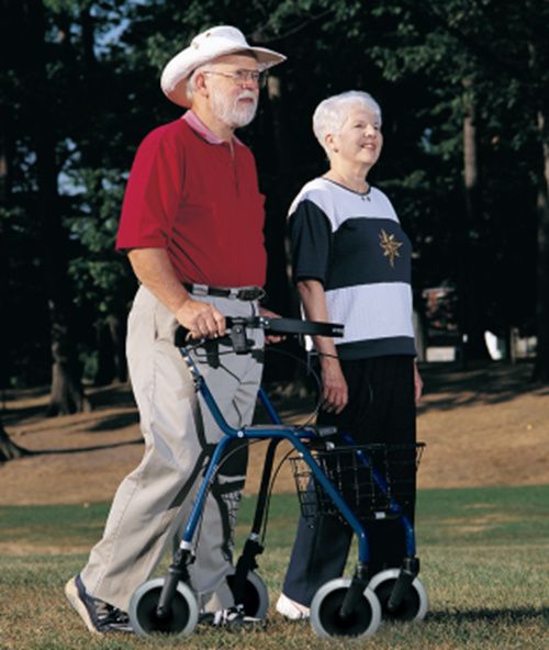 Two people walking outdoors with a walker, one of whom is using a walker.