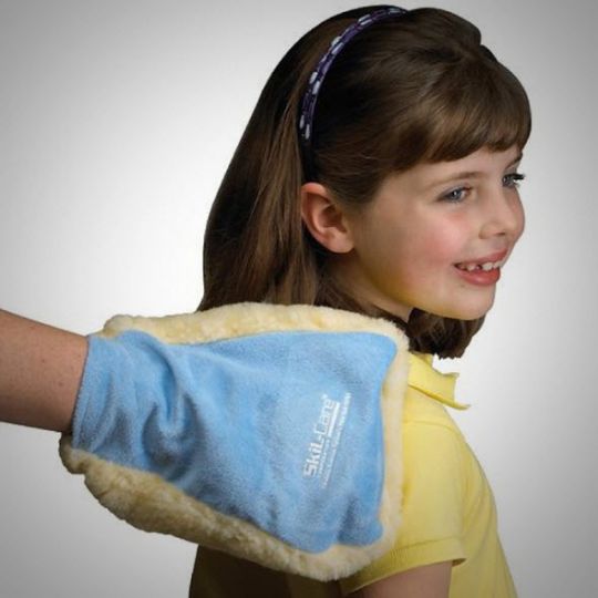 Child wearing a blue and beige heat pack on their arm against a plain background