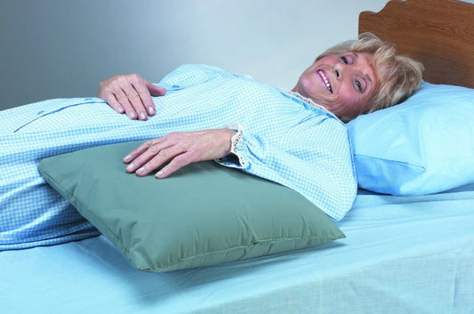 Woman lying in bed with a green pillow under her head