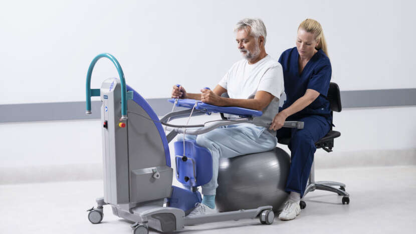 Person using a medical device with a healthcare professional assisting in a clinical setting