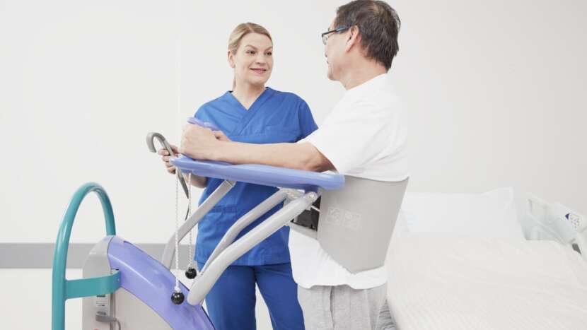 Two healthcare professionals interacting with a patient using a medical device in a clinical setting.