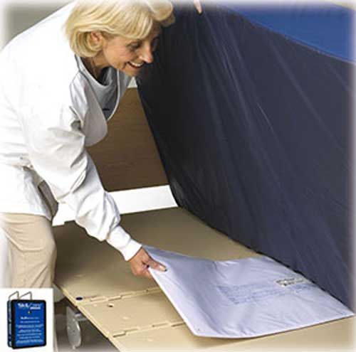 Woman applying a mattress cover to a bed with a visible brand logo.