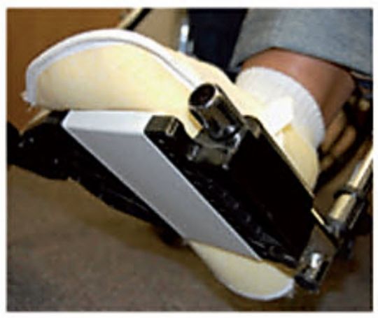 Close-up of a shoe being shined with a white cloth and black shine block on a wooden floor.