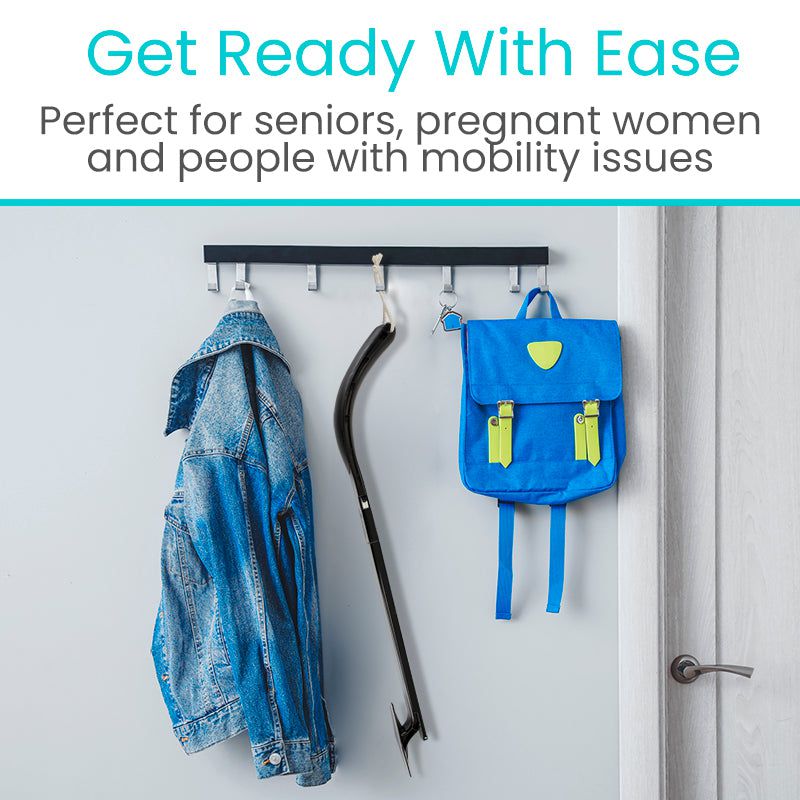 Hanging rack with a jacket, cane, and blue backpack on a white door.