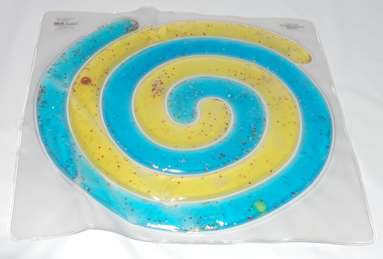 Spiral-shaped blue and yellow object in a clear plastic packaging on a white background
