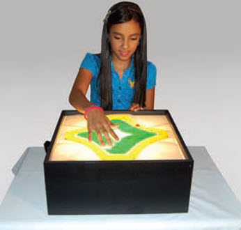 Child interacting with a light box displaying a map