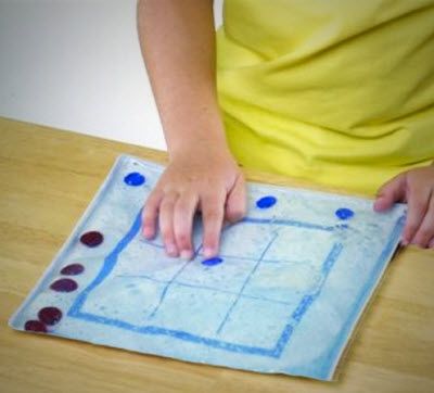 Person drawing on a piece of paper with blue markers