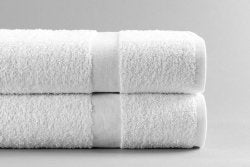 Two white towels stacked on a light gray background