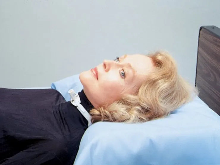Person lying on a medical examination table with a neutral background