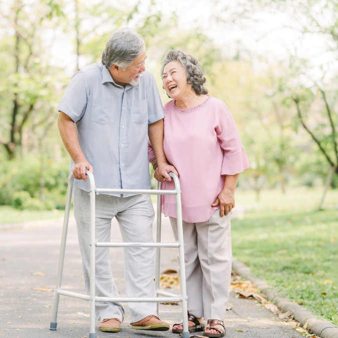 Seniors walking together - one using a walker - next to them are a few fall prevention tools 