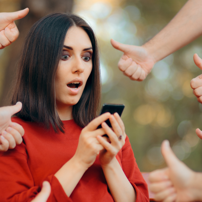 Young woman looking overwhelmed by social media notifications on her phone, representing digital distraction and fragmented attention.