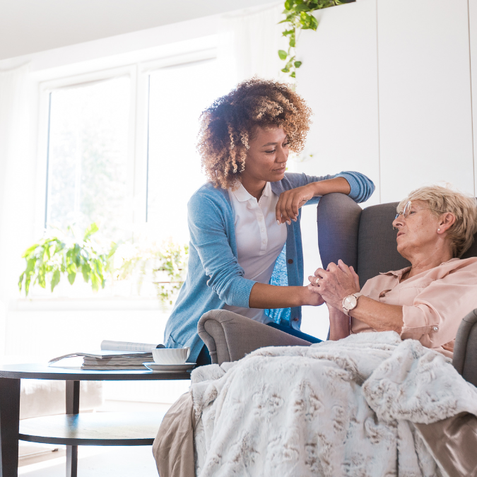 Caregiver sitting with a senior in a home care setting.
