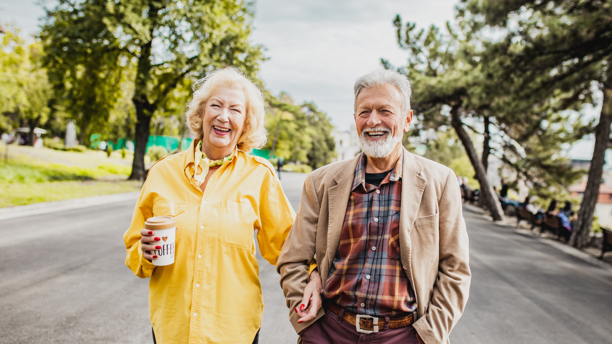 Two seniors out walking on a sunlit day