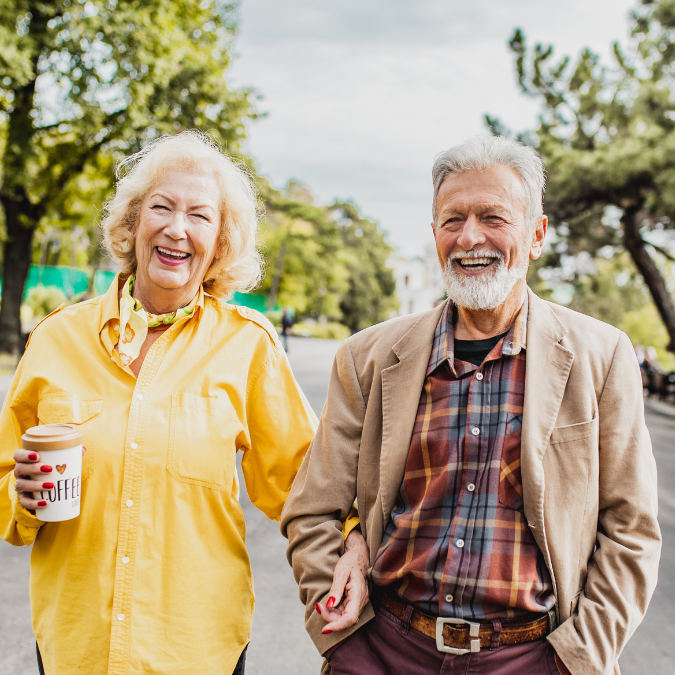Two seniors out walking on a sunlit day