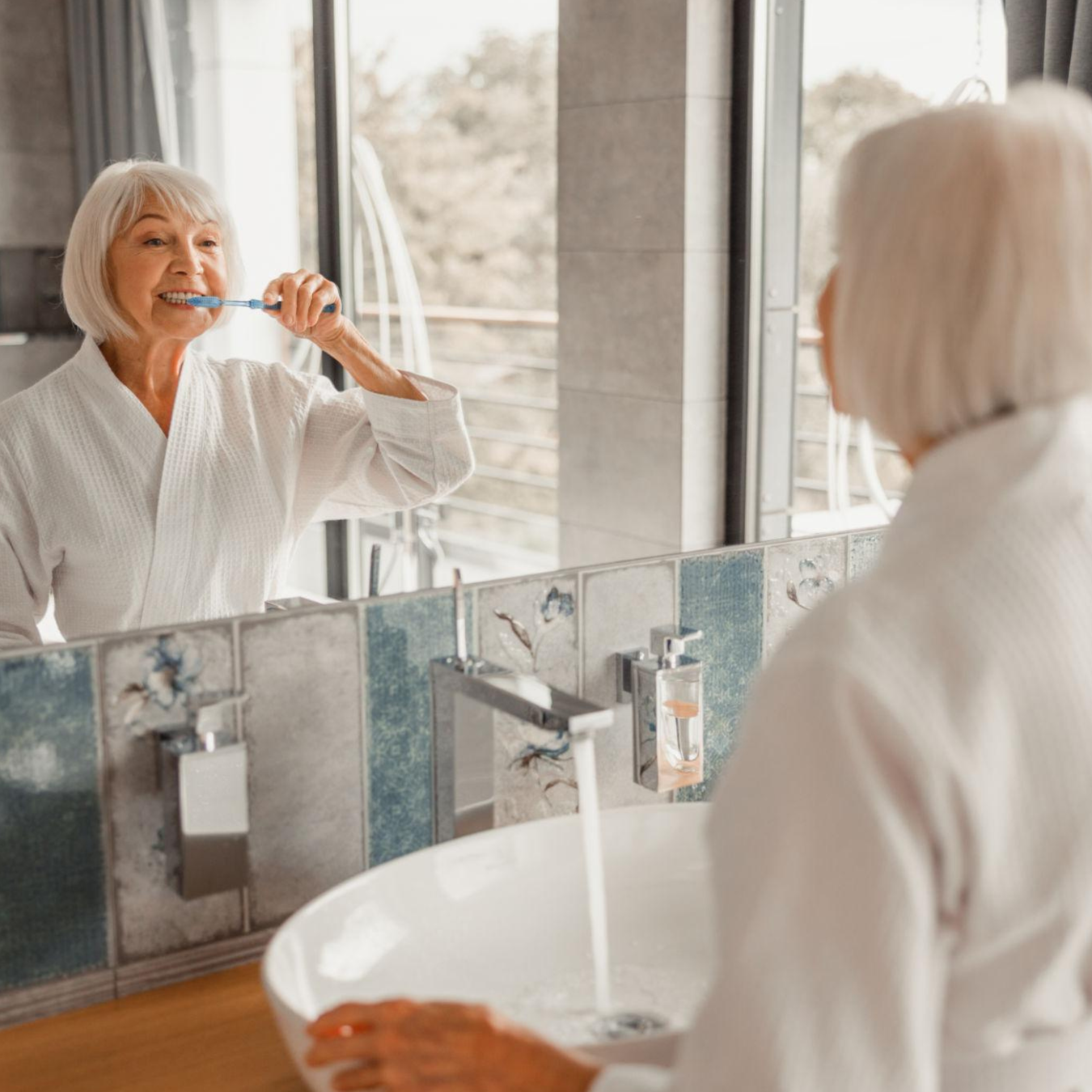 Woman brushing teeth in mirror
