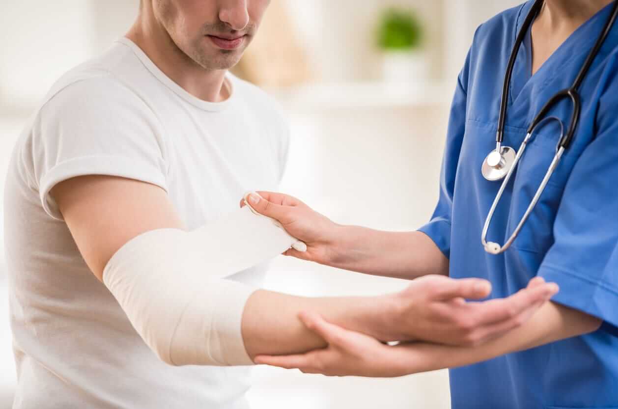 nurse assisting a patient put on a bandage