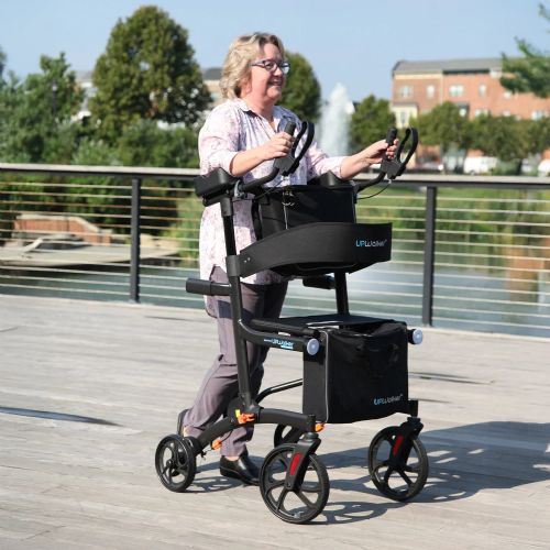 Person using a rollator on a wooden deck with trees and buildings in the background