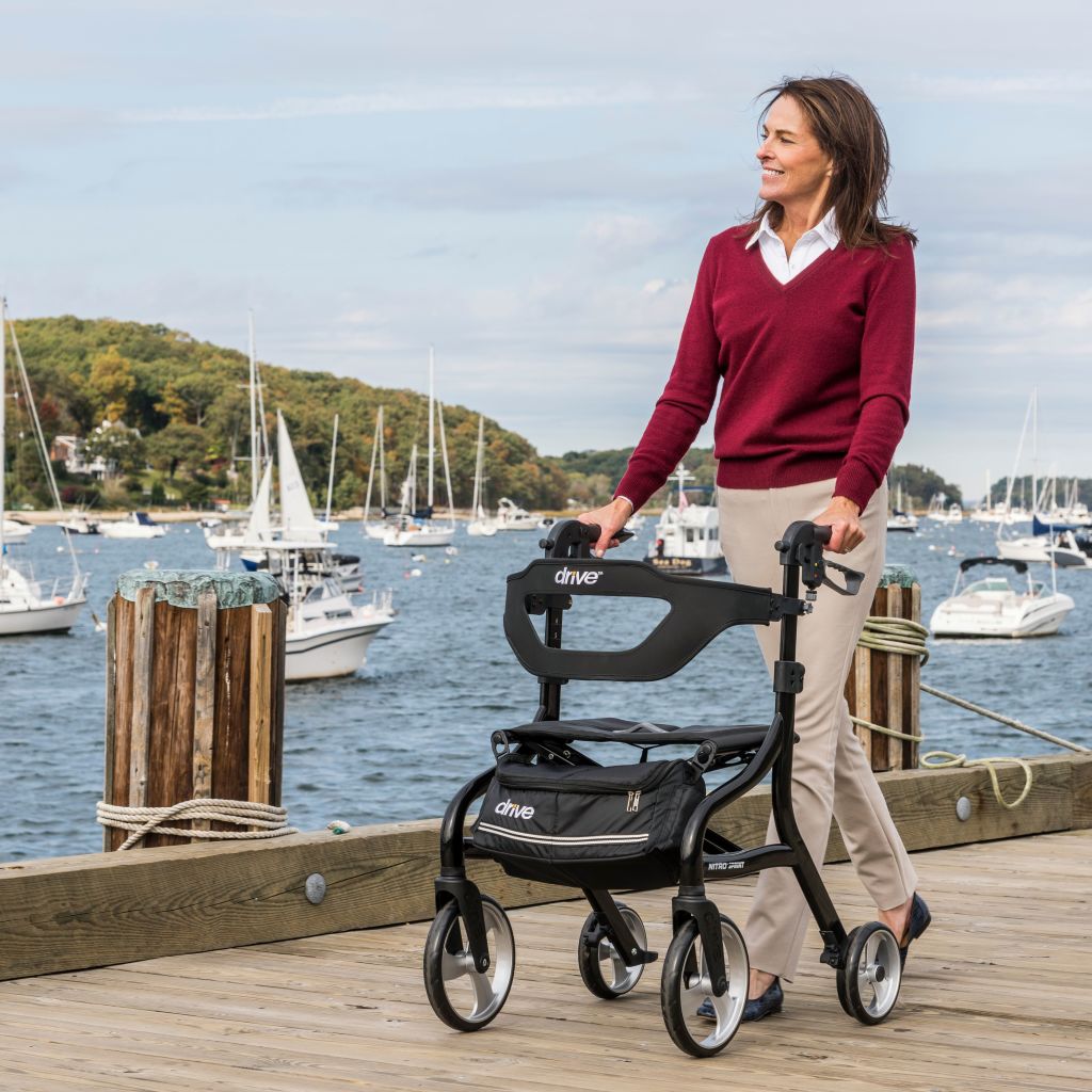 Woman using a Drive Medical Nitro Sprint rollator outdoors on a dock