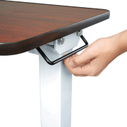 Hand adjusting a height-adjustable desk with a wooden top on a white background