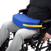Person in a wheelchair with a blue cushion and yellow strap, featuring the Dynarex brand.