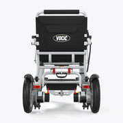 Rear view of a VOCIC electric wheelchair with a black fabric seat cushion and a silver aluminum frame, featuring dual wheels and battery units at the back, set against a light gray background.