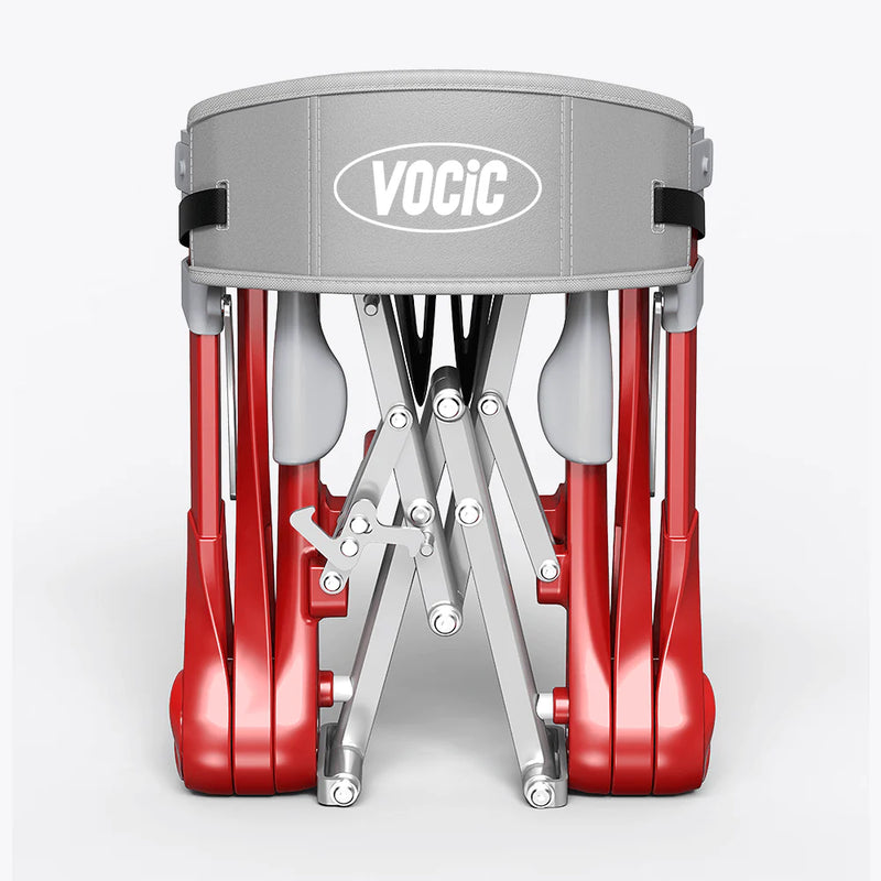 A VociC folding drum kit shown folded, featuring red drum shells, a gray head, and silver metal legs on a light gray background.