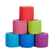 Six rolls of colorful elastic bandage stacked on a white background