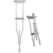 A pair of silver aluminum underarm crutches with gray padded cushions and red adjustment knobs, shown on a plain white background with one crutch standing open and the other folded.