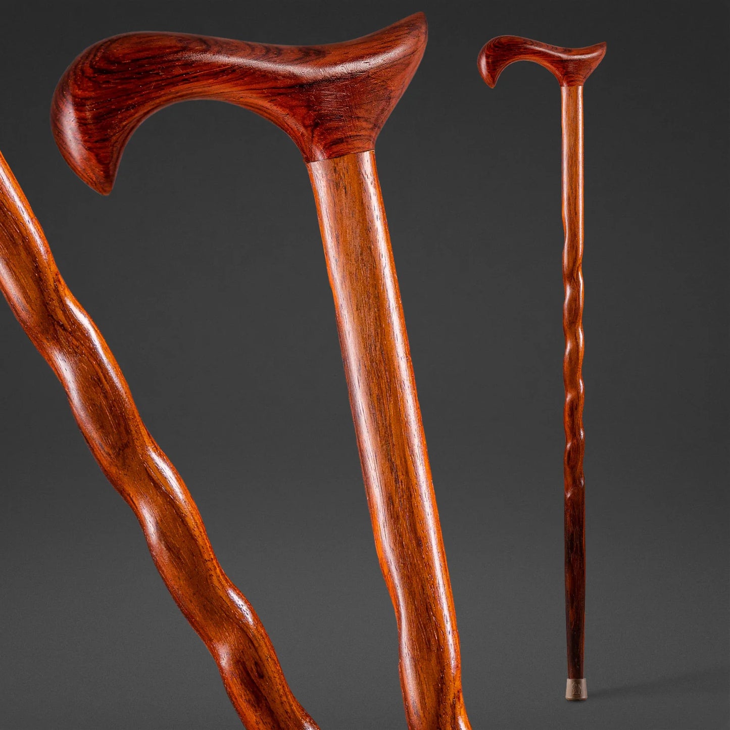 Two wooden walking canes on a dark gray background